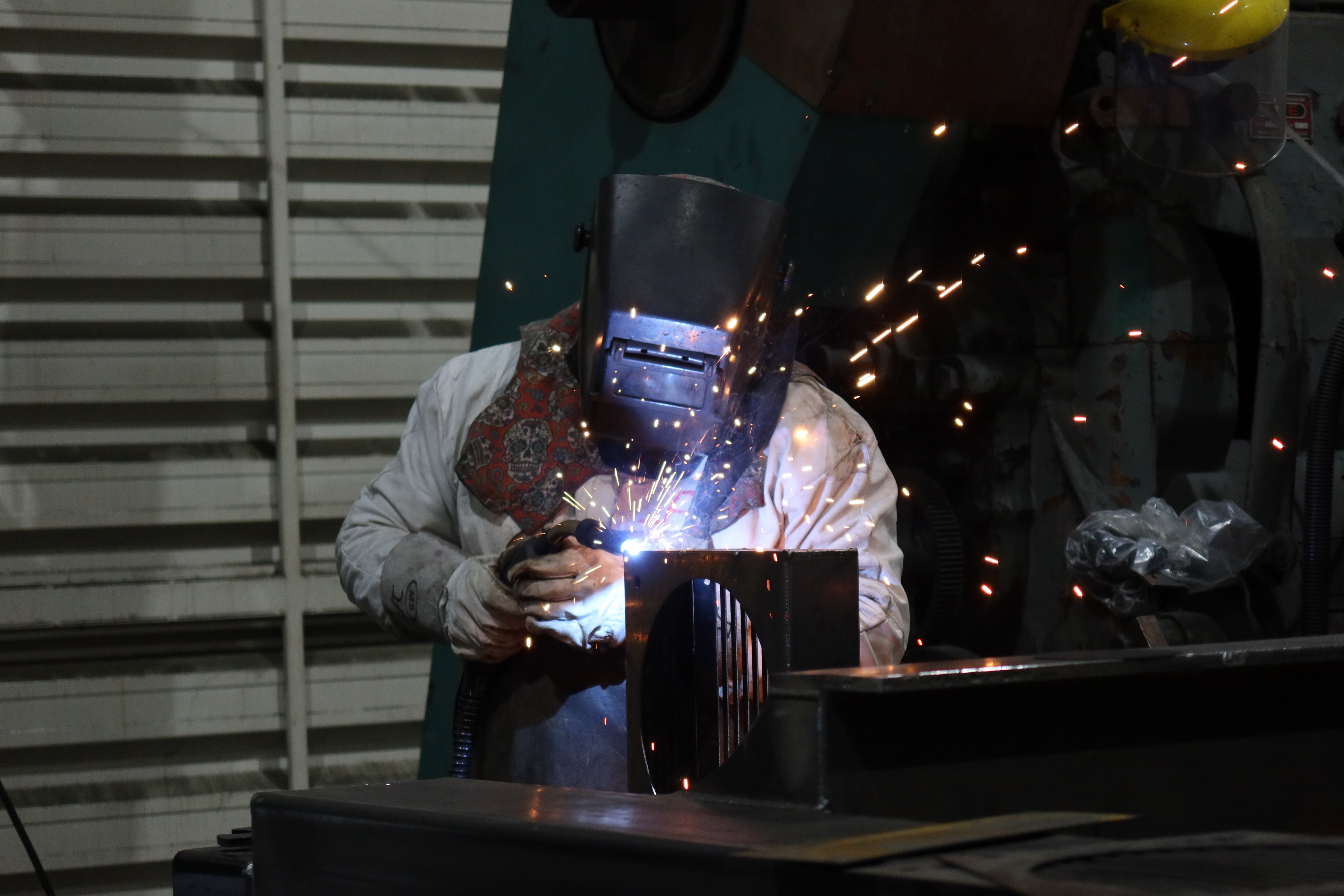 Soldador de R Ingeniería soldando un componente en el taller